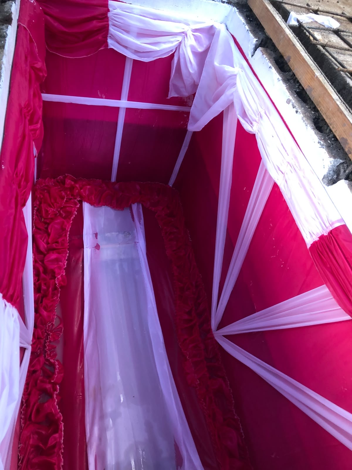 Grave vault lined with red and white drapery